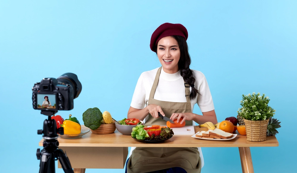 kvinde skærer grøntsager foran kamera / woman cutting vegetables in front of camera / influencer