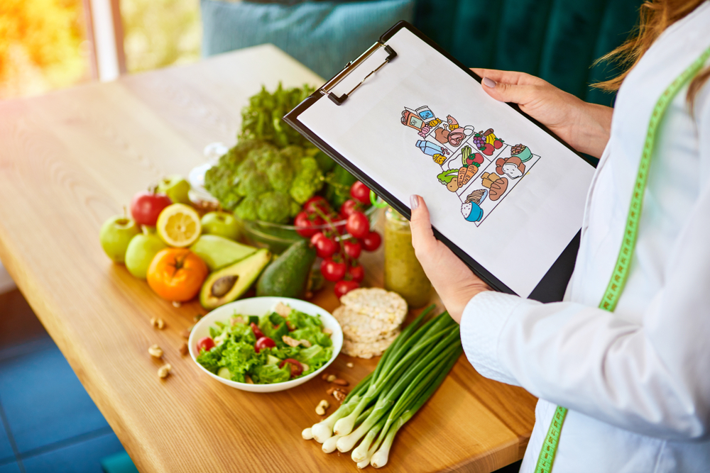 Woman in labcoat with food pyramid / kvinde med madpyramiden