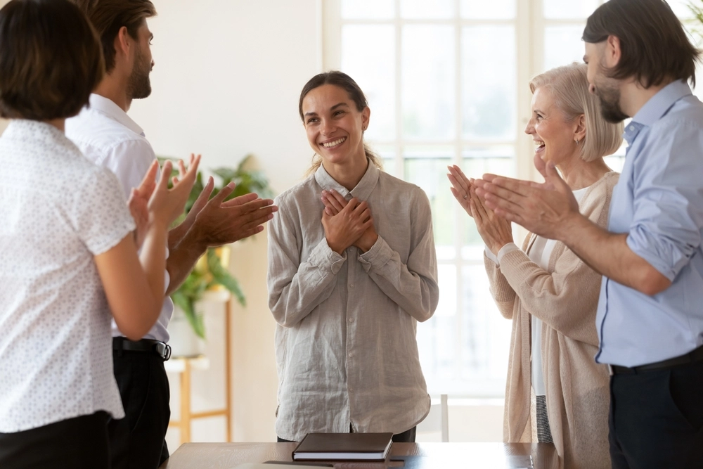 Kolleger klapper ad kvinde / Colleagues clapping for woman