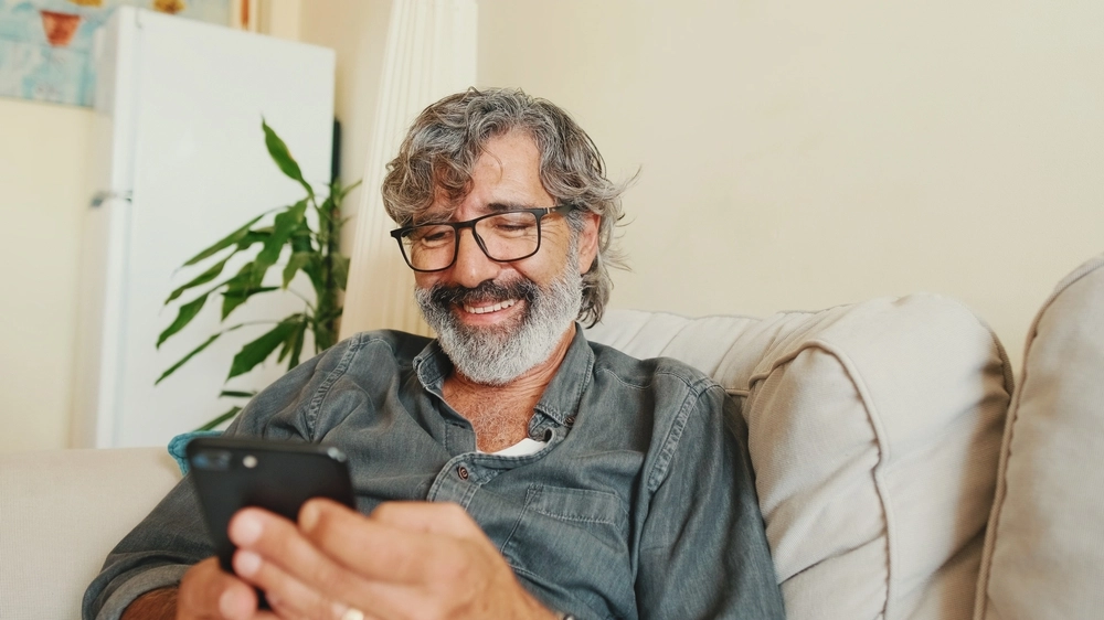 Man with smartphone on couch