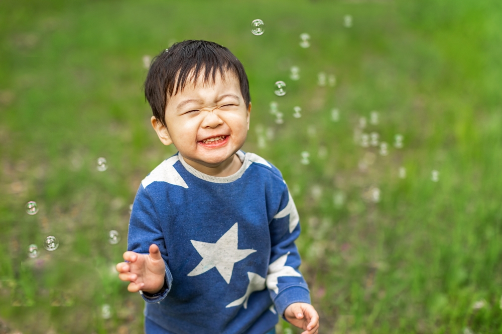 Asian,Boy,Happily,Playing,With,Soap,Bubbles,asiatisk,dreng,leger,med,sæbebobler