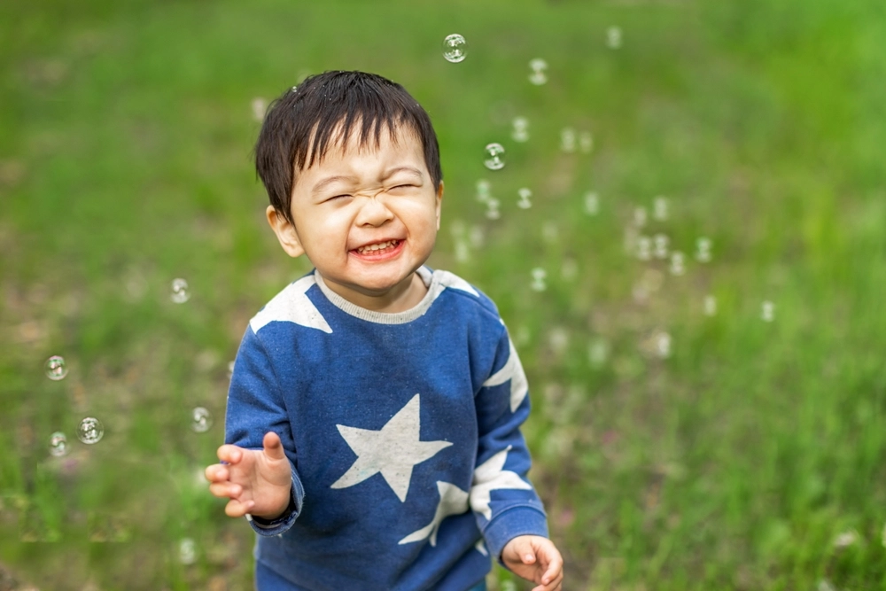 Asian,Boy,Happily,Playing,With,Soap,Bubbles,asiatisk,dreng,leger,med,sæbebobler