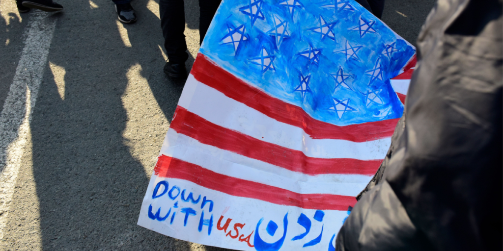 Iranian worshippers shout slogan after Friday prayer during a rally against anti-government protests on January 05, 2018 in Tehran, Iran. protesters burn American flag