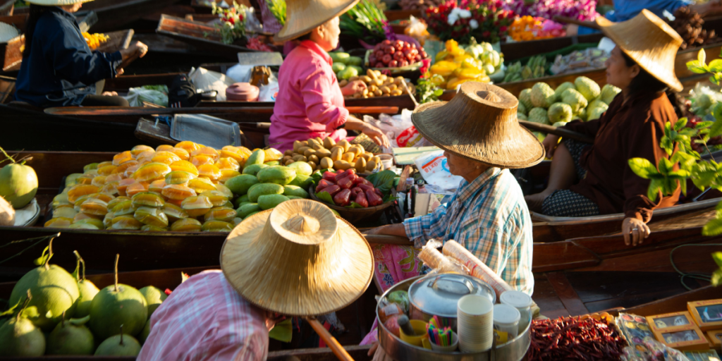 Damnoen Saduak Floating Market unidentified Local people sell fruit, local food on boats in the canal, Ratchaburi, Thailand. Famous tourist destination of Asia.