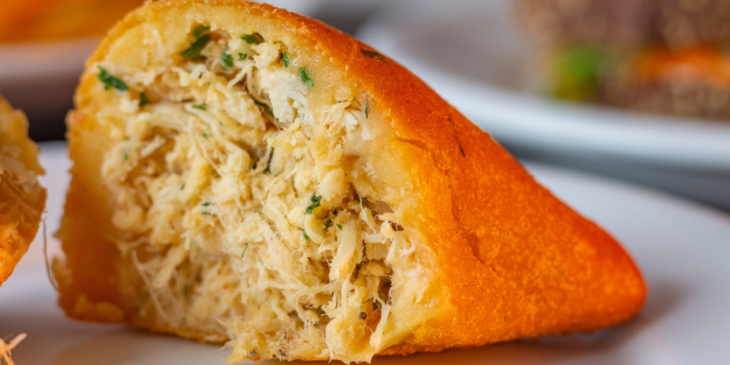 Brazilian Minced Chicken Snack, Coxinha Cut in Half With Filling Showing. Brazilian typical snack.