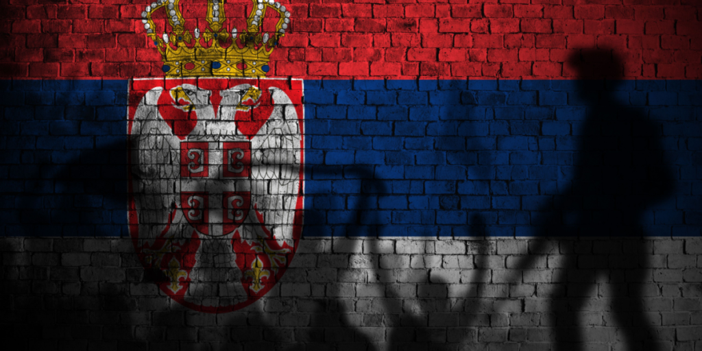 serbia flag painting on brick wall and Protesters shadow