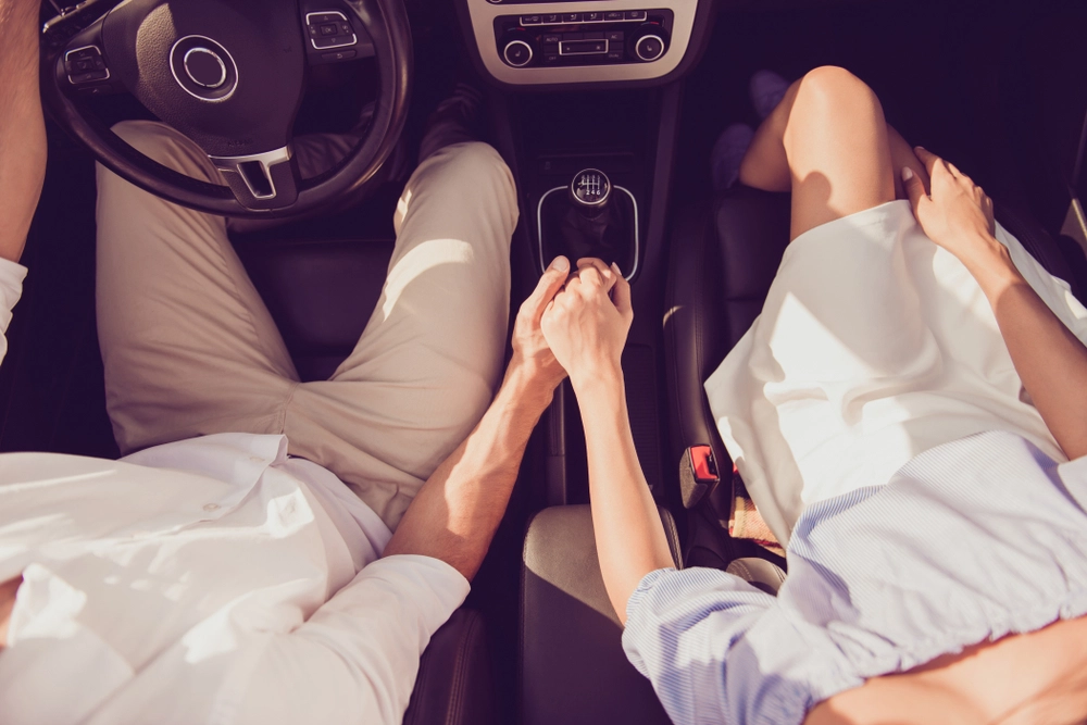 couple,driving,holding,hands,par,k&oslash;rer,holder,i,h&aring;nd