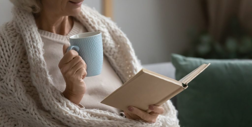 Old,Retired,70s,Lady,Reading,Book,At,Home,,Drinking,Hot, read