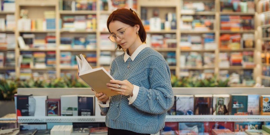 A,Focused,Young,Woman,In,Glasses,And,A,Blue,Sweater, book, reading