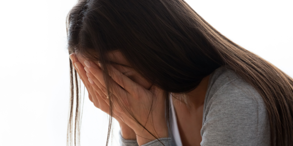 Young teenager girl woman cries covering face with hands close up image. Concept of teenage problems bullying, teen pregnancy, woman goes through addictions, break up, cheated girl, health or personal life troubles