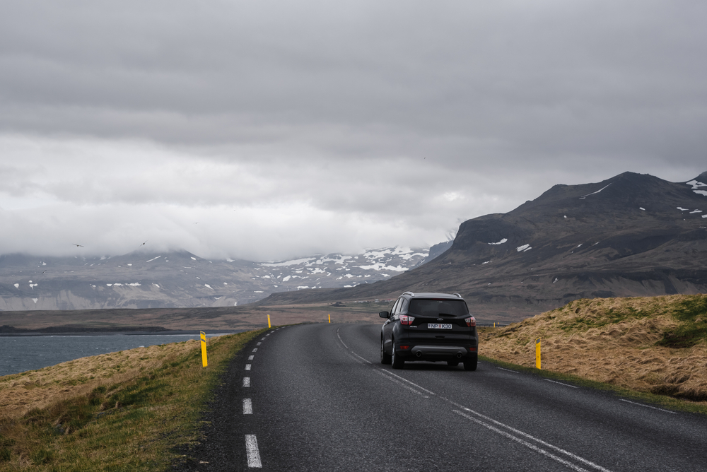 Bil kører på vej i gråvejr / car driving on road with cloudy weather