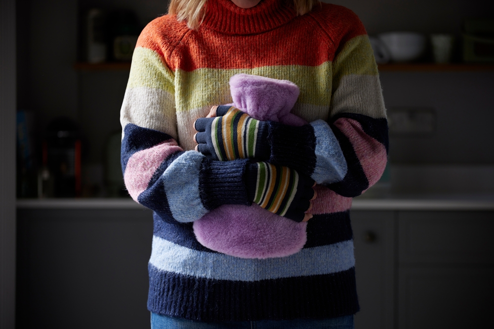 Woman,In,Gloves,Hugging,Hot,Water,Bottle,Trying,To,Keep, varmeflaske