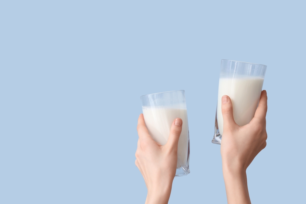 Hands,With,Glasses,Of,Milk,On,Light,Blue,Background