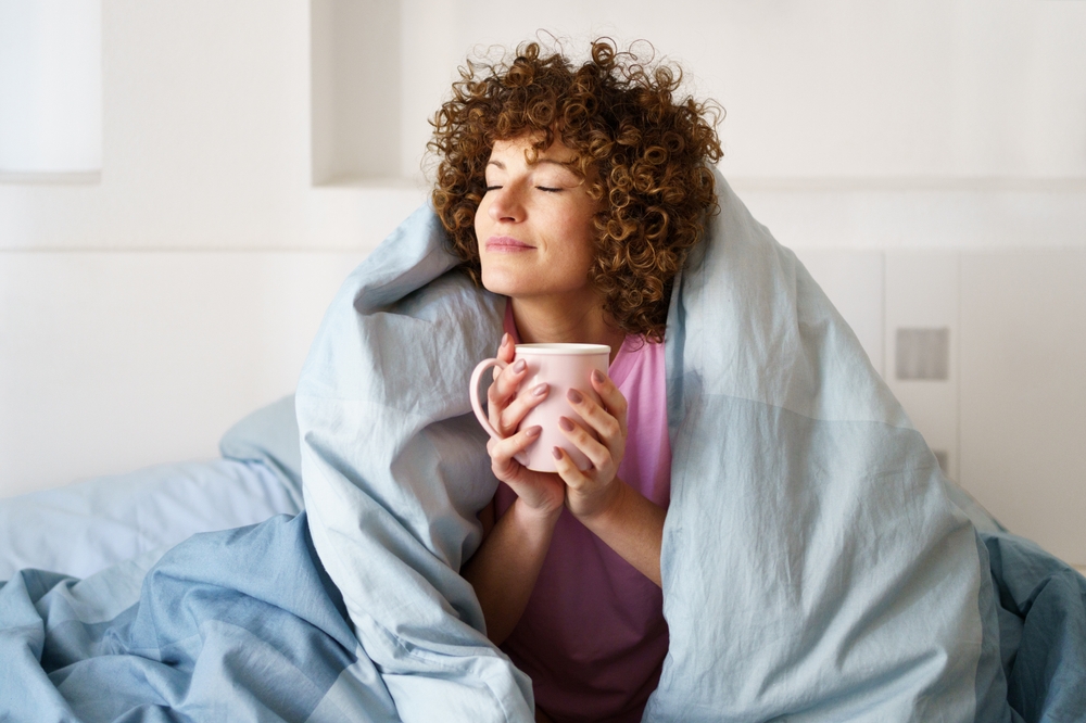 Relaxed,Curly,Woman,With,Closed,Eyes,Wrapped,In,Blanket,While