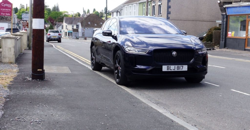 A stylish Jaguar I-Pace HSE Black, five door hatchback car, parked on a street, sort jaguar i-pace, elbil