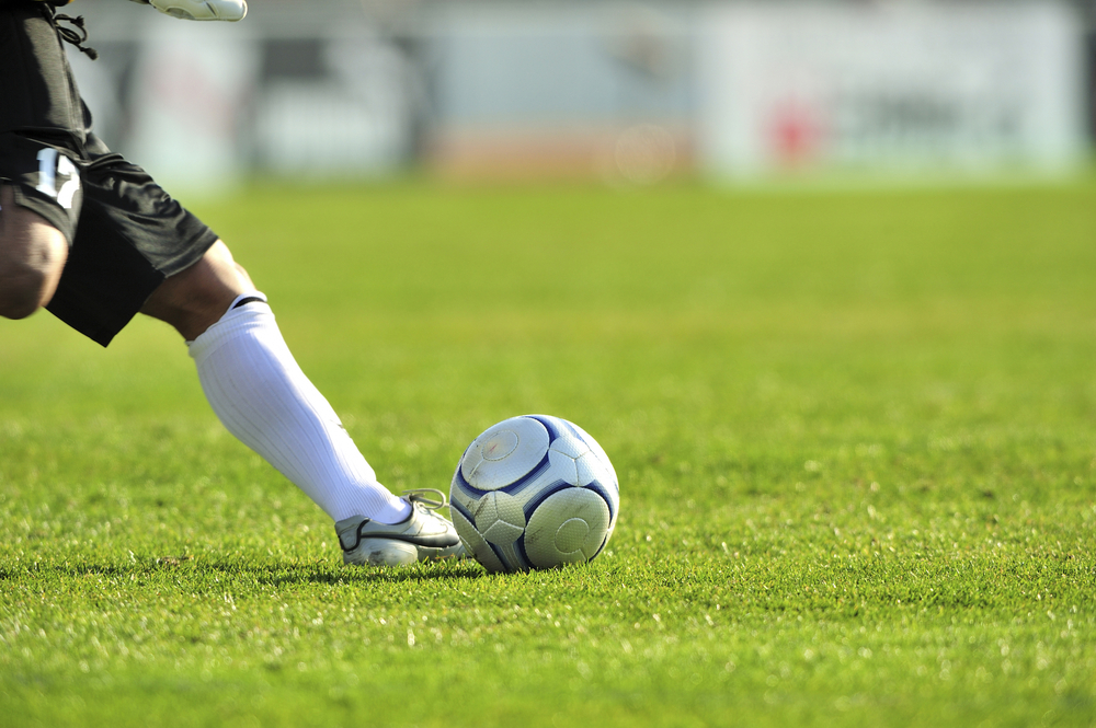 Fodboldspiller sparker til bold / Football player kicking ball