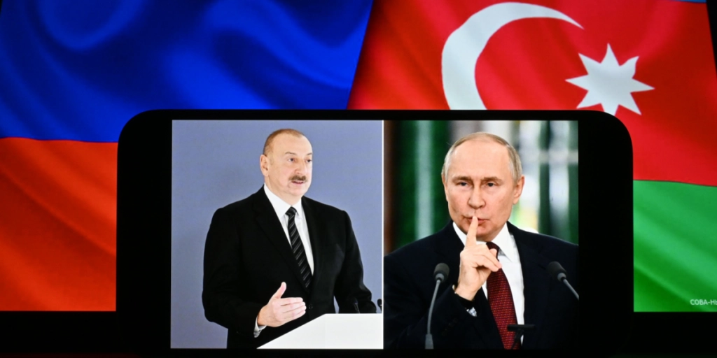 Aserbajdsjans pr&aelig;sident Ilham Aliyev og Ruslands pr&aelig;sident Vladimir Putin vises p&aring; sk&aelig;rmen. Aserbajdsjans og Ruslands flag kan ses i baggrunden