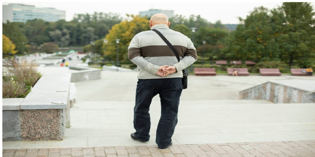 old man walking hands behind back