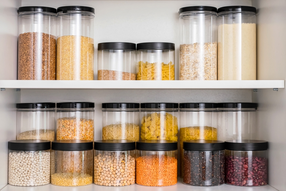 Stored,Transparent,Containers,With,Grains,And,Pasta,In,Kitchen,Cabinet.