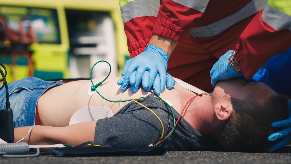paramedic and doctor during resuscitation on road against ambulance car. Patient and team of emergency medical service. Themes rescue, urgency and health care.