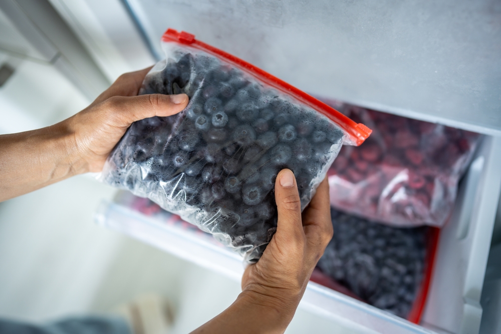 Woman,Hands,Hold,Zip,Bag,With,Blueberries,,Putting,Into,Freezer.