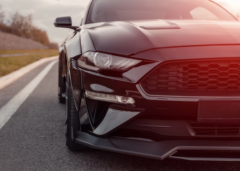 Black,Ford,Mustang,Parked,By,A,Curb,On,Highway.,Front