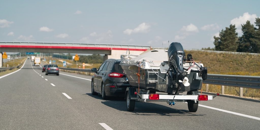 Vehicle With Boat Trailer Driving On Road