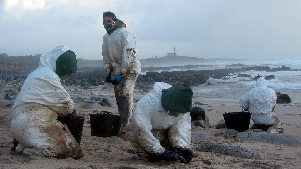 Oil spill response volunteers clean a beach in Spain.
