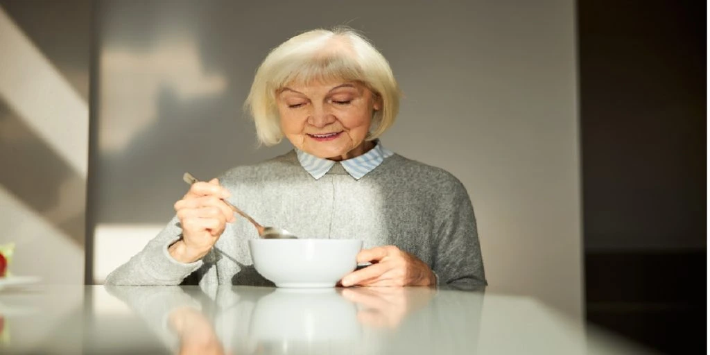 old woman eating breakfast