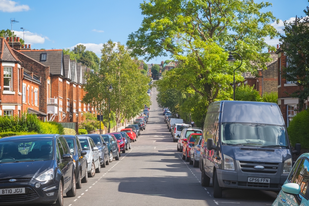 An uphill street of terraced houses with cars parked in resident bay around Crouch End, North London, parkering på vej i London