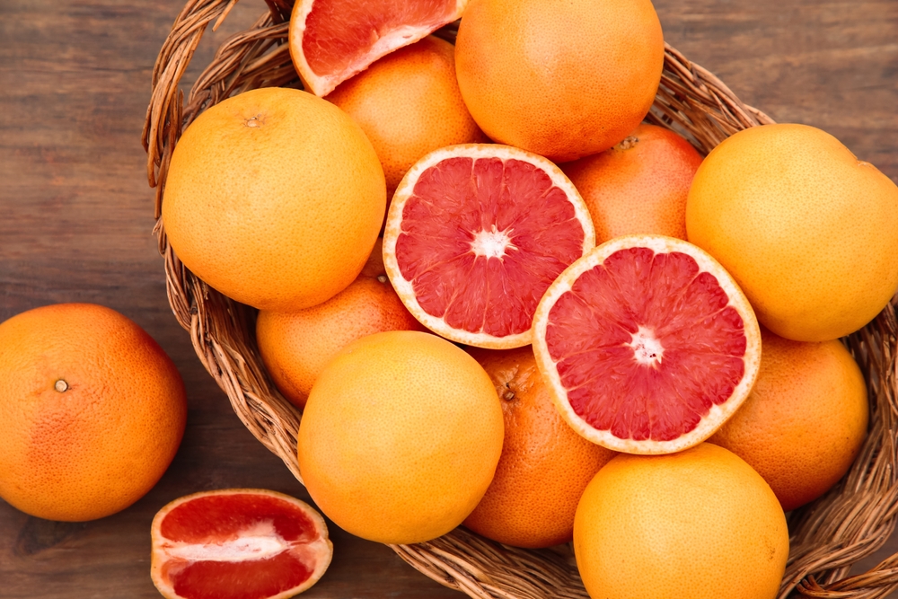 Wicker,Basket,With,Fresh,Grapefruits,On,Wooden,Table,,Flat,Lay