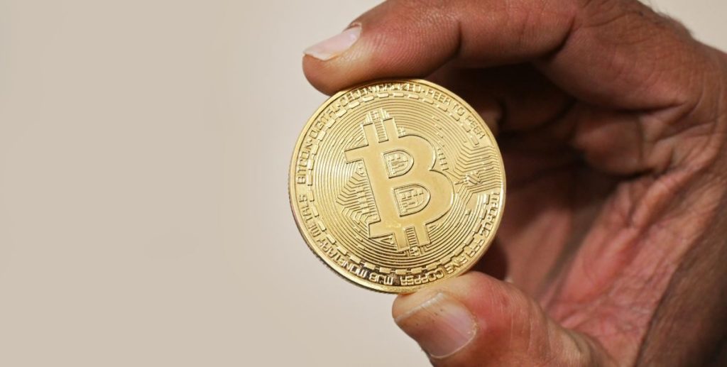 Holding_Bitcoin_cryptocurrency_coin