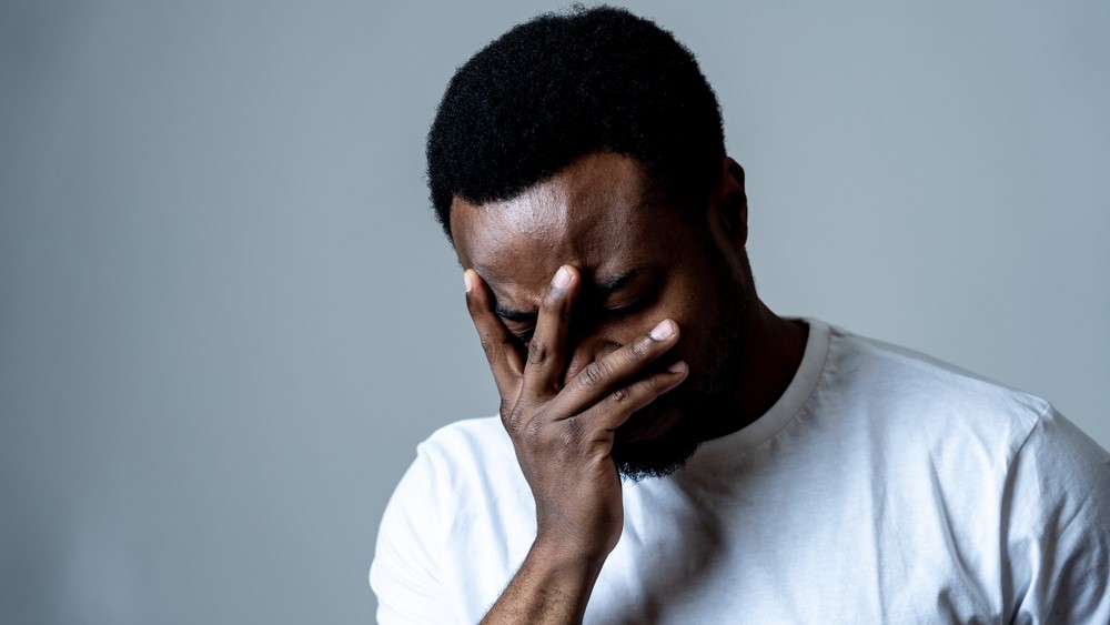 man sad and depressed suffering depression feeling sorrow and unpleasant pain in human emotions facial expressions and depression concept. Isolated on grey blue background.