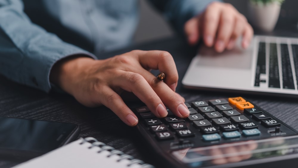 Businessman using calculator bookkeeping payroll and budget tax. Business document finance accounting investment