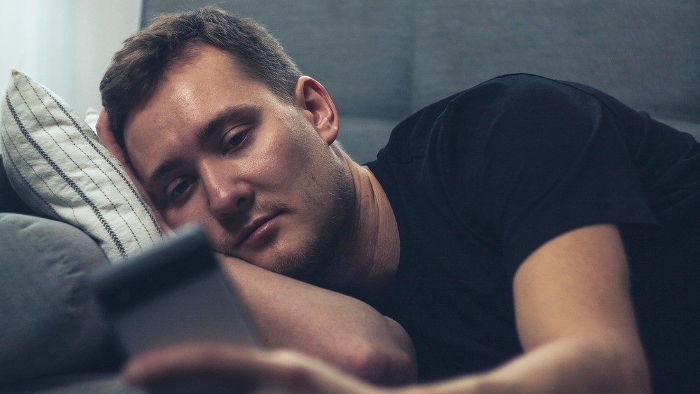 lonely loneliness men phone bed