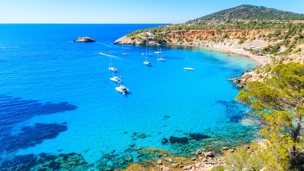 Sailing boats on Cala d'Hort bay with beautiful azure blue sea water, Ibiza island, Spain, travel, vacation