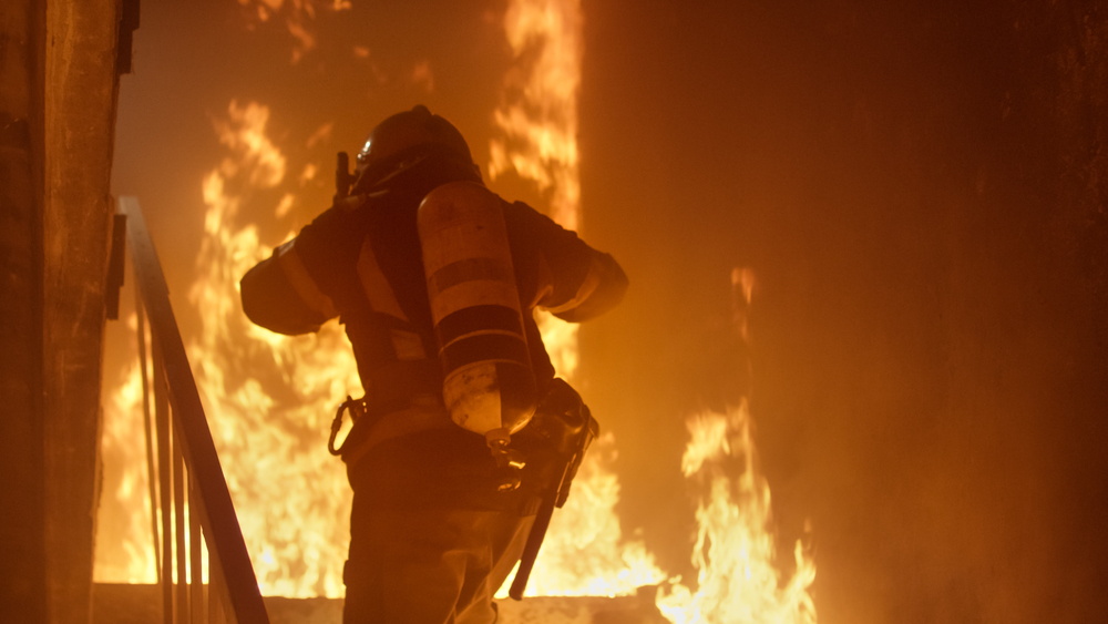 Brave,Firefighter,With,Oxygen,Cylinder,Runs,Up,The,Stairs.,Raging