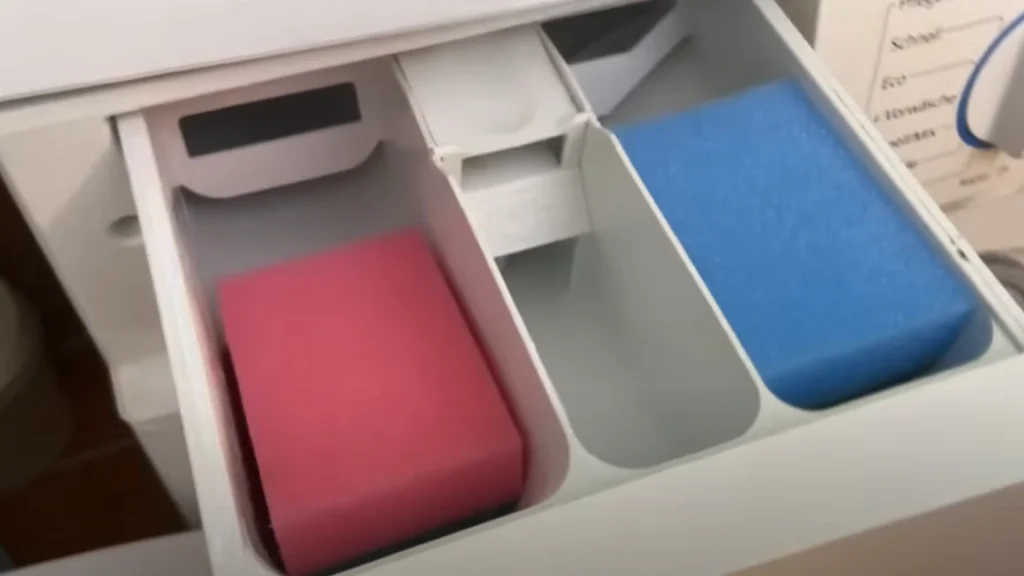 Han lägger två disksvampar i tvättmaskinens fack och gör en sak till: Kort därefter glänser maskinen som ny