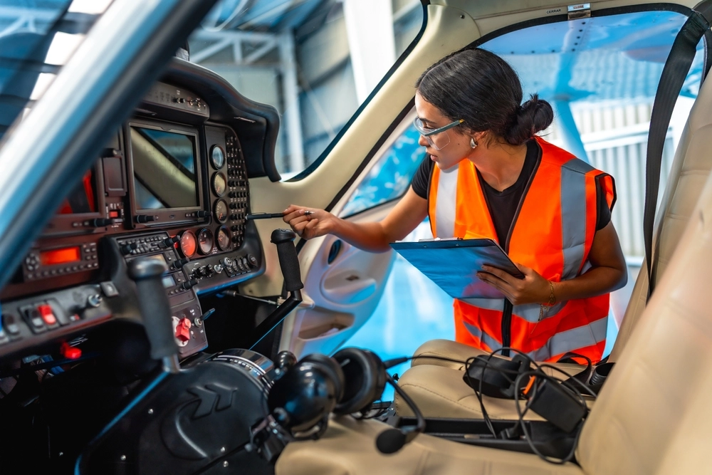 Female aircraft maintenance engineer using checklist while inspecting control panel inside cockpit of light aircraft, fly, avionics,mekaniker