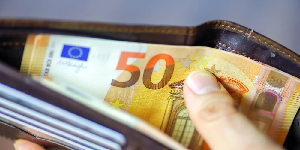 hand holding wallet with 50 euros