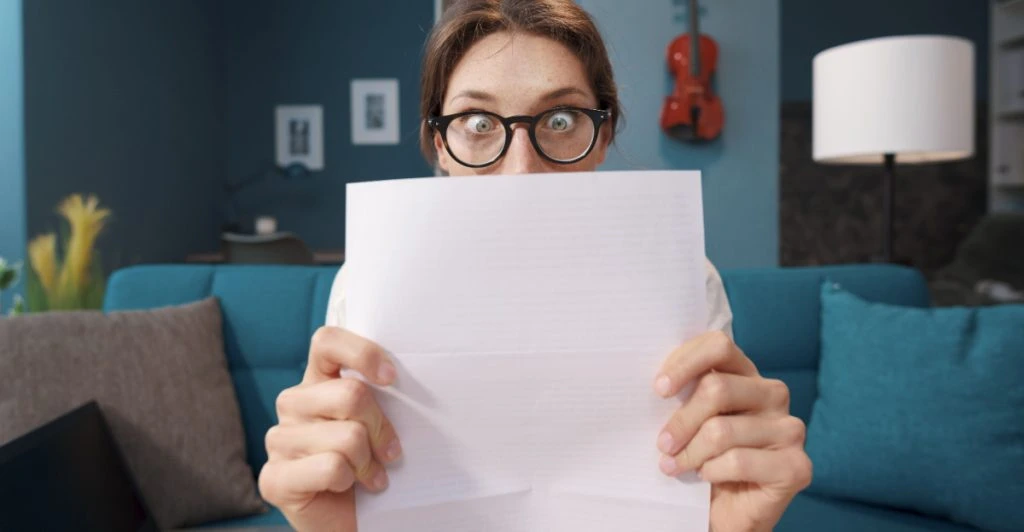 Chockad kvinna läser brev