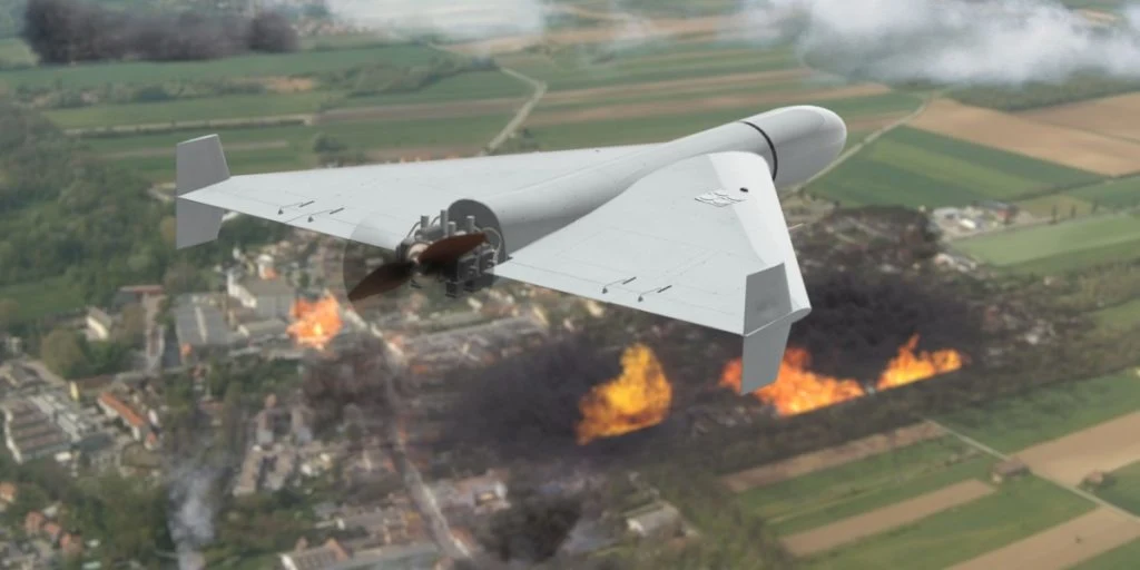 An unmanned military drone flies in the sky over a destroyed and burning city