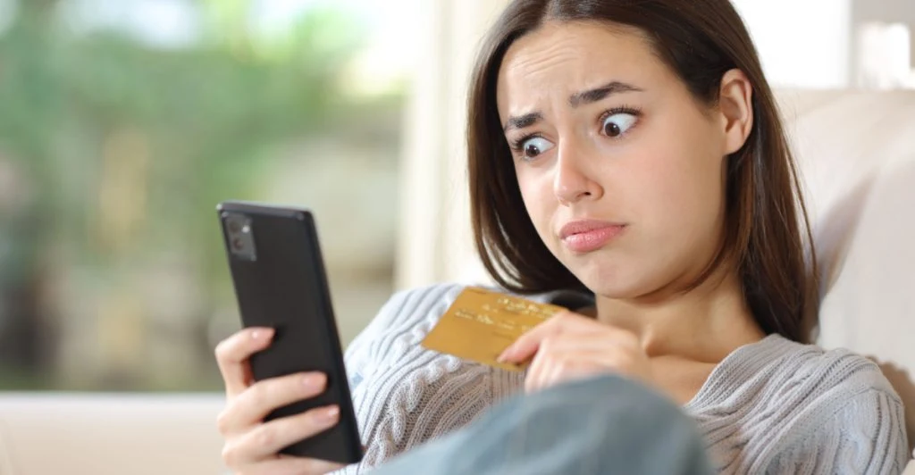 Kvinna tittar på mobilen i chock