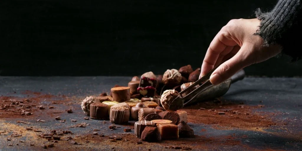 Luxury chocolates woman female hand grabbing one