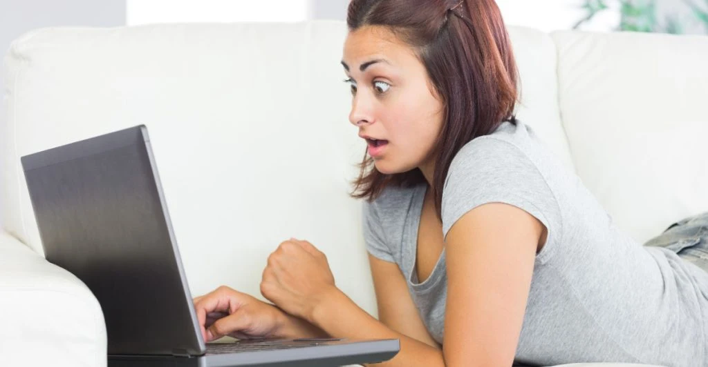 Kvinna chockad av vad hon ser på skärmen