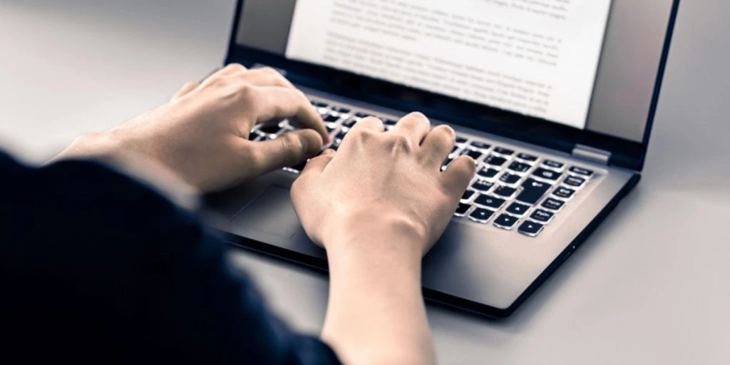 Author or blogger writing on laptop