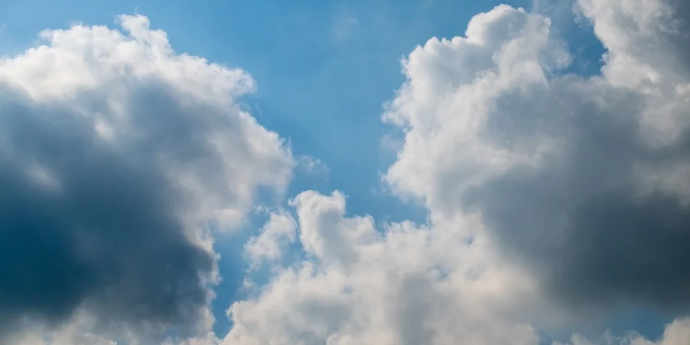 Hvide og grå skyer mod en lyseblå himmel