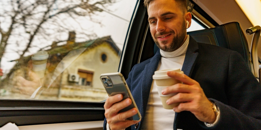 Man scrollar iPhone på tåget