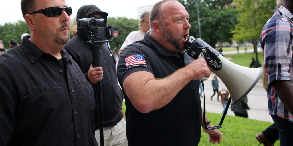 Austin, Tx/USA - Apr. 18, 2020: Alex Jones addresses demonstrators protesting Covid-19 stay at home orders as he leaves a rally at the Capitol heavily promoted by his Infowars website.