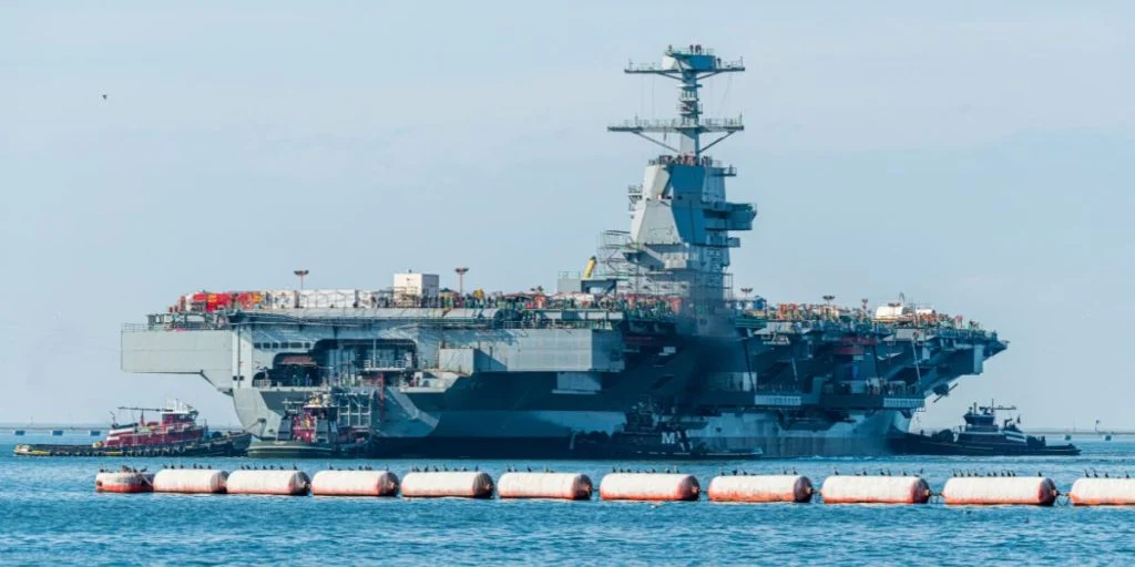 Newport News, Virginia / United States - Dec 16, 2019: The USS John F Kennedy being moved from its initial construction dry-dock to an outfitting dock at Newport News Shipbuilding.